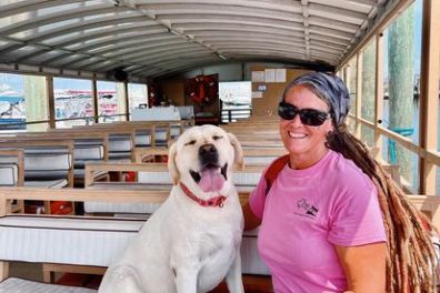 a person holding a dog posing for the camera